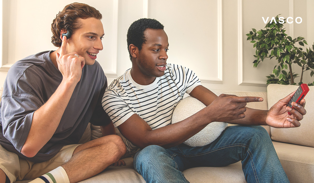 znajomi korzystający ze słuchawek z tłumaczem AI oraz urządzenia Vasco Translator Q1 do tłumaczenia na żywo w domu