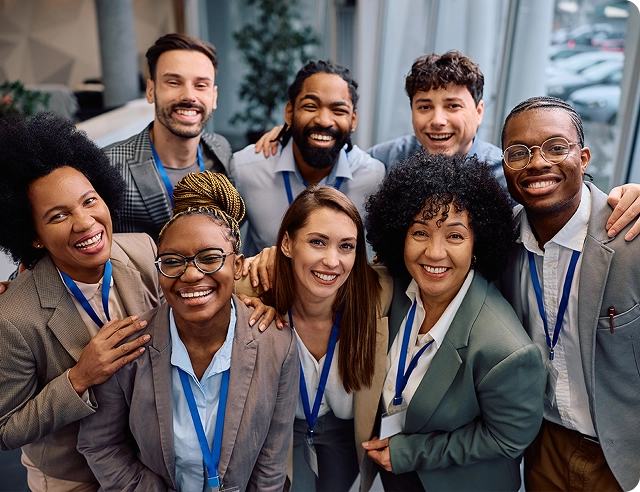 A smiling group of office workers representing diverse cultures.