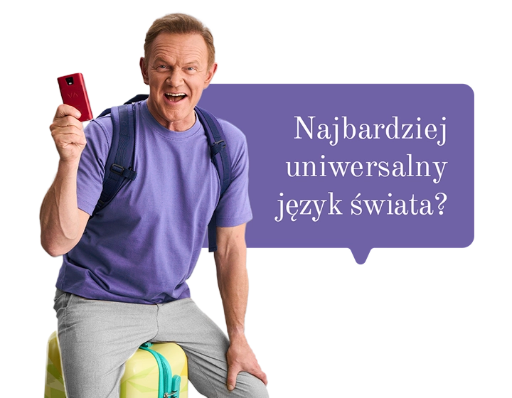 Uśmiechnięty Cezary Pazura w czerwonym swetrze, owinięty lampkami, trzyma w ręce pudełko Vasco Translatora. W tle dymek z tekstem: Najbardziej uniwersalny język świata?
