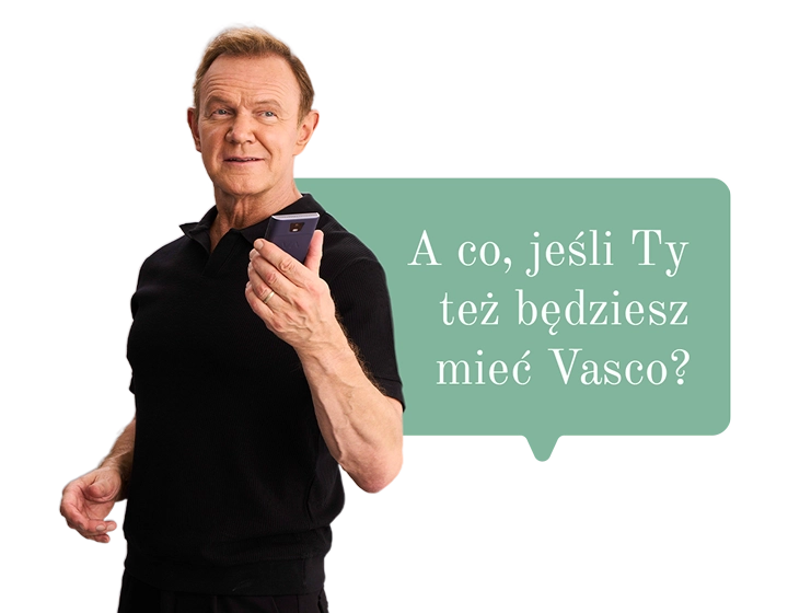 Cezary Pazura w świątecznym swetrze trzyma prezent i otwiera go, a w środku widać pudełko Vasco Translatora. W tle dymek z tekstem: A co jeśli podarujesz komuś Vasco?