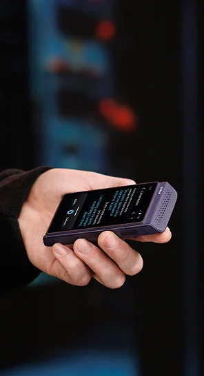 Osoba trzymająca w dłoni urządzenie Vasco Translator Q1.